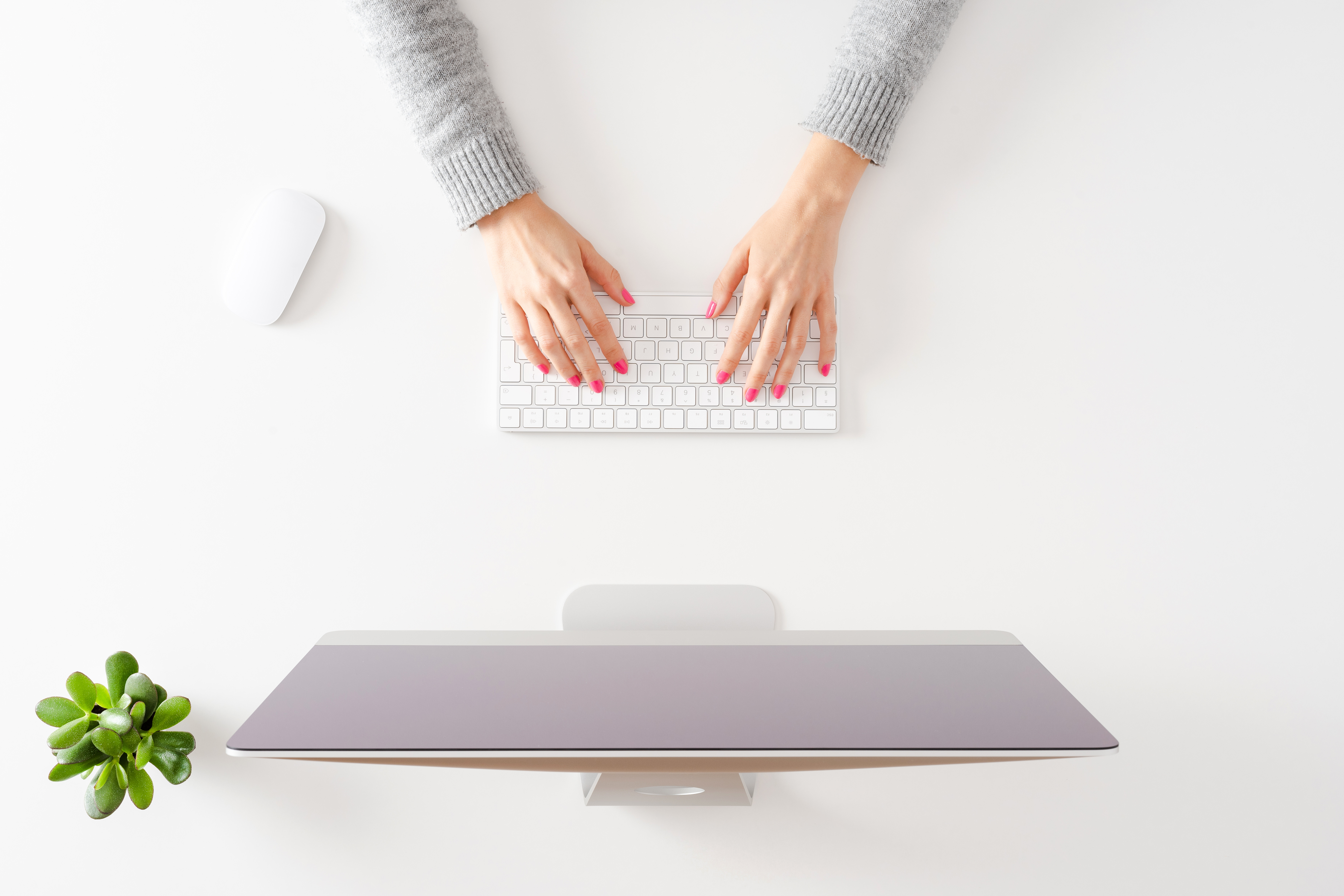 Overhead shot of woman’s hands working on computer